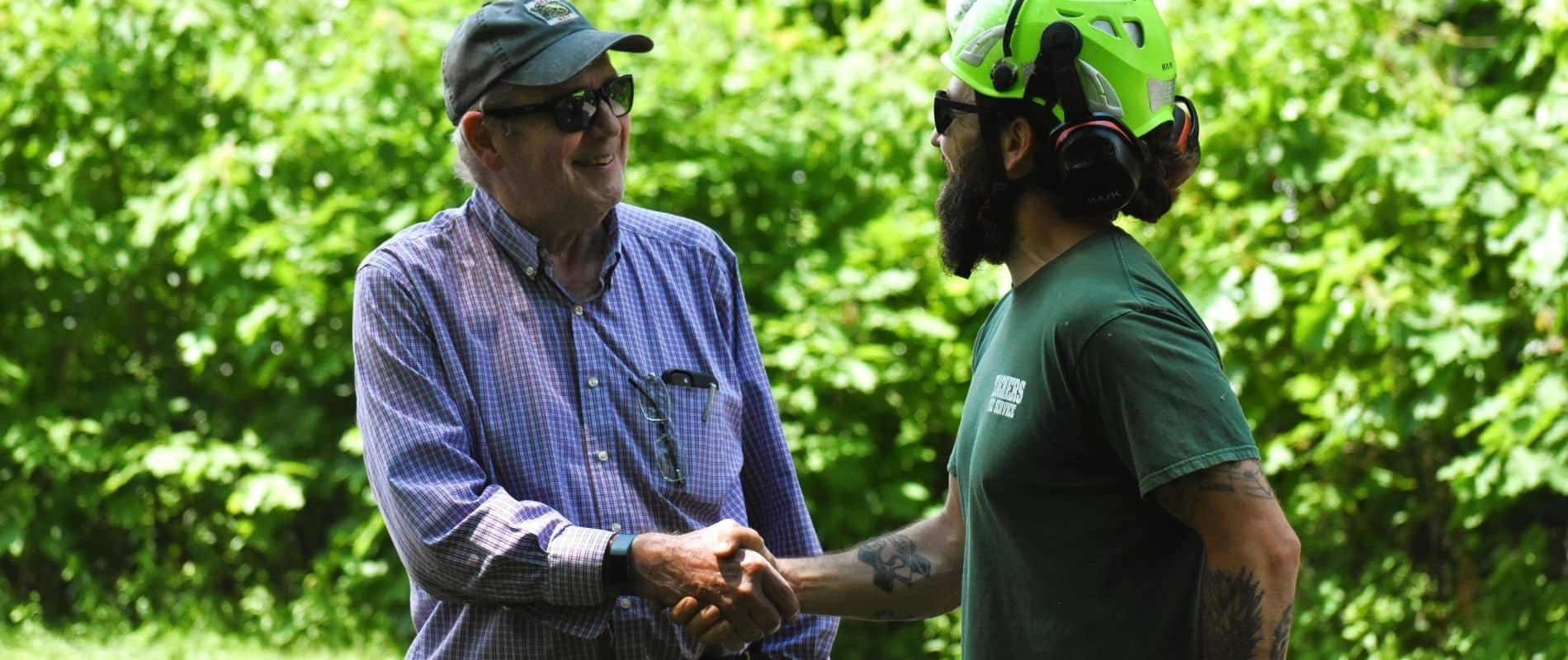 Teachers Tree Service arborist shaking hands with a satisfied client outdoors