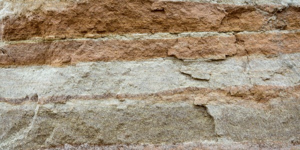 Close-up of compacted, layered soil showing dense compressed strata