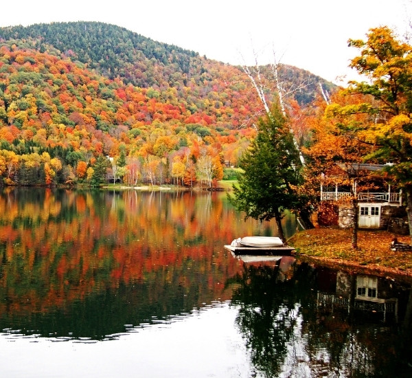 Vermont lakeside property with peak fall color reflected on calm water